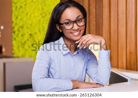 Making business look good. Attractive young African woman looking at you and smiling while standing at the reception