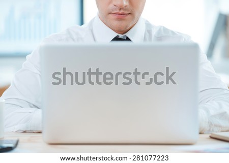 Smart gadget means smart solutions. Close-up of businessman working on laptop while sitting at his working place