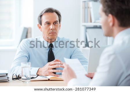 Business meeting. Two business people sitting in front of each other in the office while discussing something
