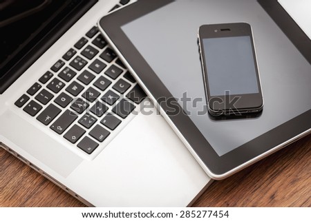 Smart helpers for good business. Close-up of laptop with digital tablet and mobile phone laying on the wooden desk