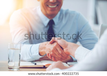 Good deal. Close-up of two business people shaking hands while sitting at the working place Foto stock © 