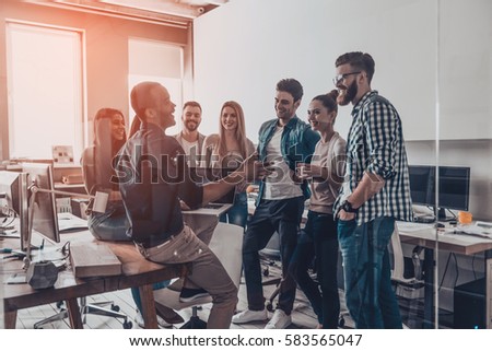 A group of people interacting with each other in an office workplace