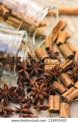 Star anise and cinnamon sticks spilling out of glass jars