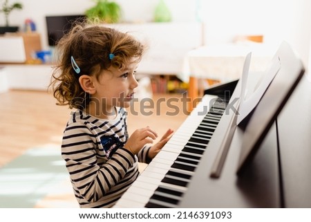 Similar – Image, Stock Photo Smiling child playing piano in cozy room in daylight