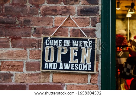 “Come in we’re open and awesome.” A playful sign invites customers into a store. ストックフォト © 