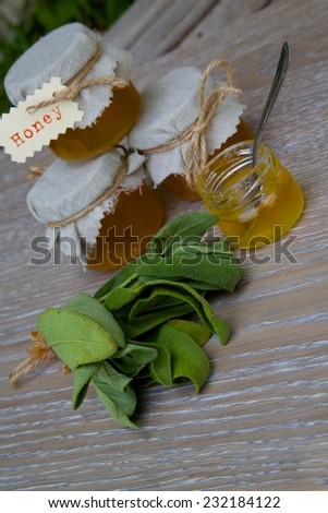 Sage honey and fresh leaves of garden sage on the wooden surface