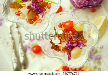 Light salad in a dessert cups: raisins,green onion,almond flakes,grape,pomegranate grains, cherry tomatoes