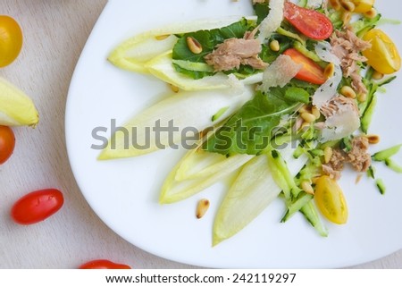 Vitamin winter salad: endive,rucola,tuna,cedar wood nuts,cherry tomatoes,parmesan cheese,cucumber. Background