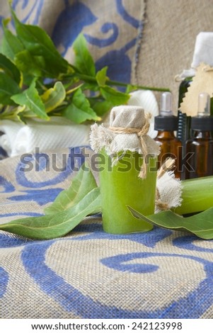 A bottle of bay leaf body scrub. Bay leaves in the background
