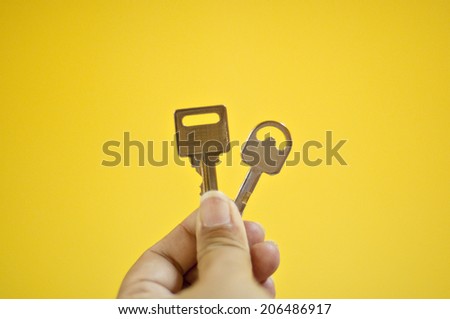 a hand holding two types of key