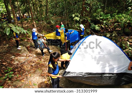 Kawang, Papar March 7, 2015 : A group of school girls working together pitching up tents for school extracurricular activity at  Kawang camping site.