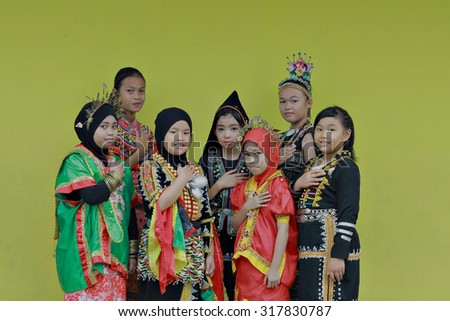 Kota Kinabalu, Sabah. September 15,2015: School children standing against green school wall attending school in their multiracial traditional costumes to celebrate Malaysia Day at SK. Kolombong, Sabah