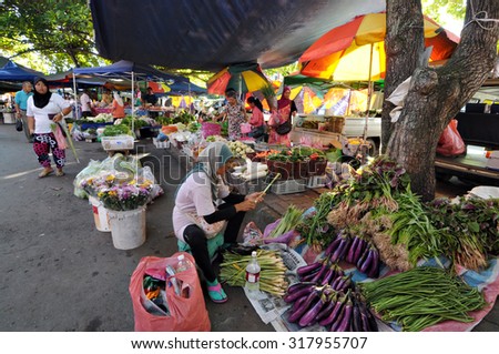 Tuaran, Sabah. May 25, 2013: A vegetable seller cleaning fresh lemongrass at her vegetable stall at local weekend market locally known as \