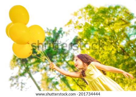 Happy girl with yellow balloons