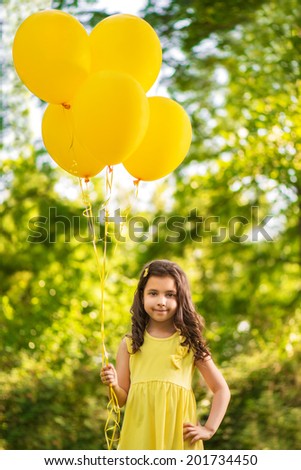 Happy girl with yellow balloons