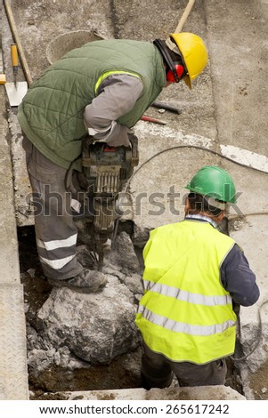 street construction workers repairing sidewalks and pipelines
