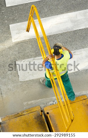 construction worker carrying a mobile metal walkway  in the street city