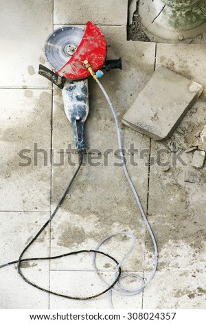 electric grinder with tiles slabs to repair  sidewalks for  construction mason  worker in the street city