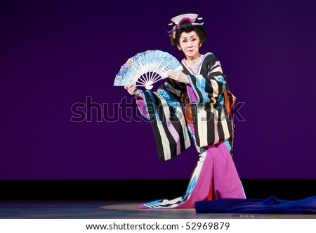 KAGOSHIMA CITY, JAPAN - OCTOBER 27, 2007:   An elderly senior Japanese dancer in kimono perform with a fan onstage in  the Taniyama Furusato Matsuri October 27, 2007 in Kagoshima City, Japan.