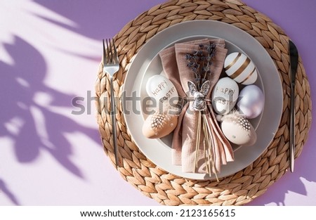 Banner. Table setting. A plate with a rabbit on a napkin, lavender and Easter eggs on a fashionable background of 2022 is a veri pery. Top view. The concept of a happy Easter holiday for cafes and res Stock fotó © 