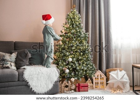 Similar – Image, Stock Photo Boy decorating Christmas tree in evening