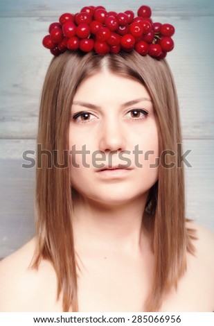 Portrait close up of young beautiful woman with cherry  crown on head, on wooden background.Beauty Model Woman Face. Perfect Skin with healthy hair .Vintage style.
