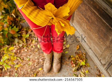 Young woman with leaves in her hands. Autumn october background
