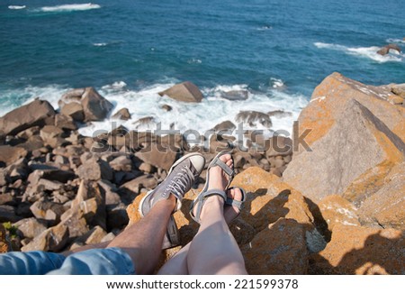 Couple in love sitting on the Cabo da Roca rocks and looking on  atlantic ocean,the western point of Europe - Portugal