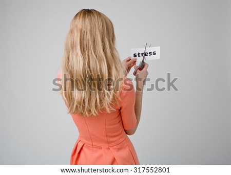 Young beautiful woman cutting paper with word stress . Idea for solution problems and depression