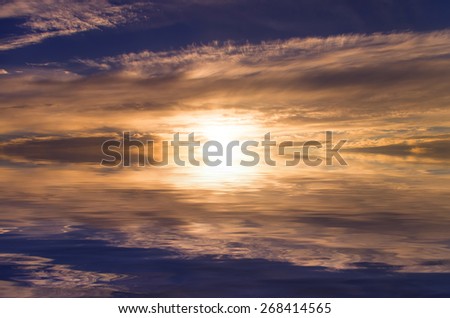 extremely bright sunset , reflected in the smooth surface of the water