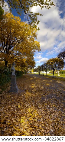Sunny autumn vertical panorama of Kuskovo manor in Moscow. Alley with statues