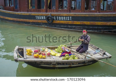 HA LONG BAY, VIETNAM - MAY 25: Unidentified woman sells fruits from her boat on Ha Long bay, Vietnam on MAy 25, 2011. Floating markets are very popular as it is only way to move around.