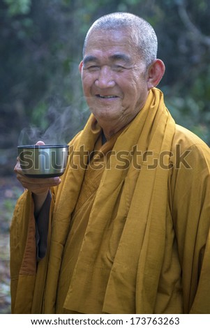 TERENGGANU, MALAYSIA - APRIL 10, 2013: An unidentified Buddhist monk smile and having his breakfast on April 10, 2013 in Terengganu, Malaysia