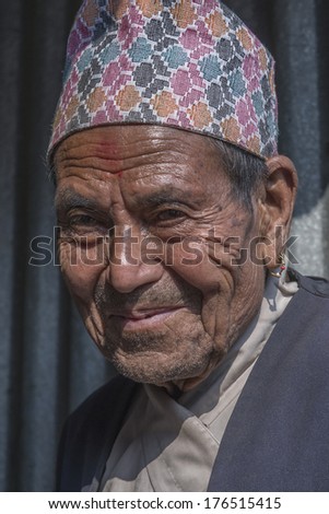 PATAN, NEPAL - MARCH 23: Unidentified Nepali old man with traditional Topi hat poses for camera in Patan, Nepal on March 23, 2013.