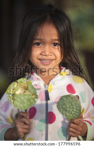 SIEM REAP, CAMBODIA - DEC 31, 2012 : An unidentified  girl smile and poses for a photo on December 31, 2012 in Siem Reap, Cambodia.