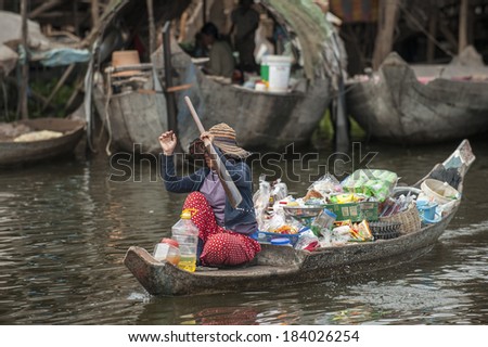 TONLE SAP, CAMBODIA - DECEMBER 24, 2011: Unidentified Cambodian woman rowing her sampan and selling goods in Tonle Sap water village, near Siam Reap,Cambodia on December 24, 2011