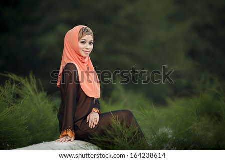 Muslimah lady wearing blouse with hijab isolated with green background