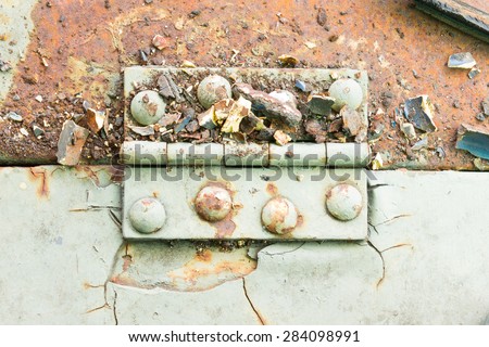 Old metal hinge and rust and rivet on old metal sheet of auto part in horizontal view. Grunge or retro or old background for industry design.