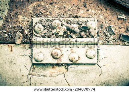 Old metal hinge and rust and rivet on old metal sheet of auto part in horizontal view high contrast style. Grunge or retro or old background for industry design.