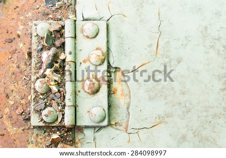 Old metal hinge and rust and rivet on old metal sheet of auto part. Grunge or retro or old background for industry design.