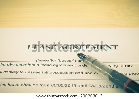 Lease Agreement Contract Document and Pen Horizontal View on Wood Table in Vintage Style. Legal document for business event