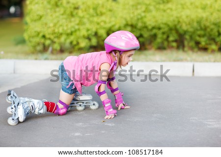 Little girl in roller skates getting up to move on