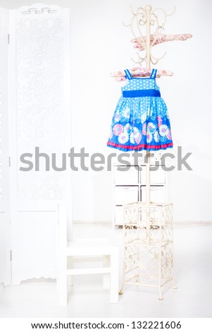 Blue kid dress hanging high up on the rack