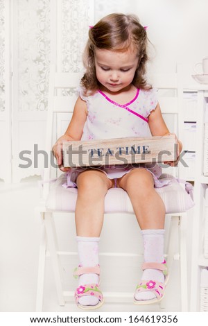 Cute little girl holding a wooden box with tea bags