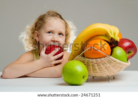Lovely little girl eating a big red apple