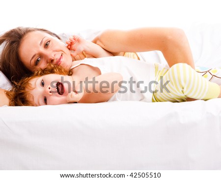 Beautiful mother and daughter lying in bed