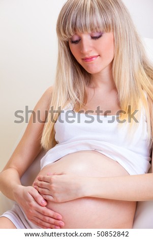 Happy pregnant woman with her hands on belly