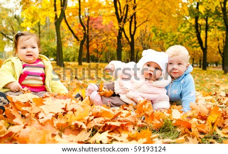 Kids sitting on ground covered with leaves