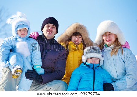 Happy family in warm winter clothes against blue  sky