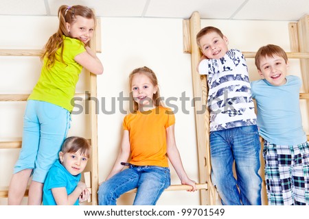 Active children climbing up the gymnastic wall bars
